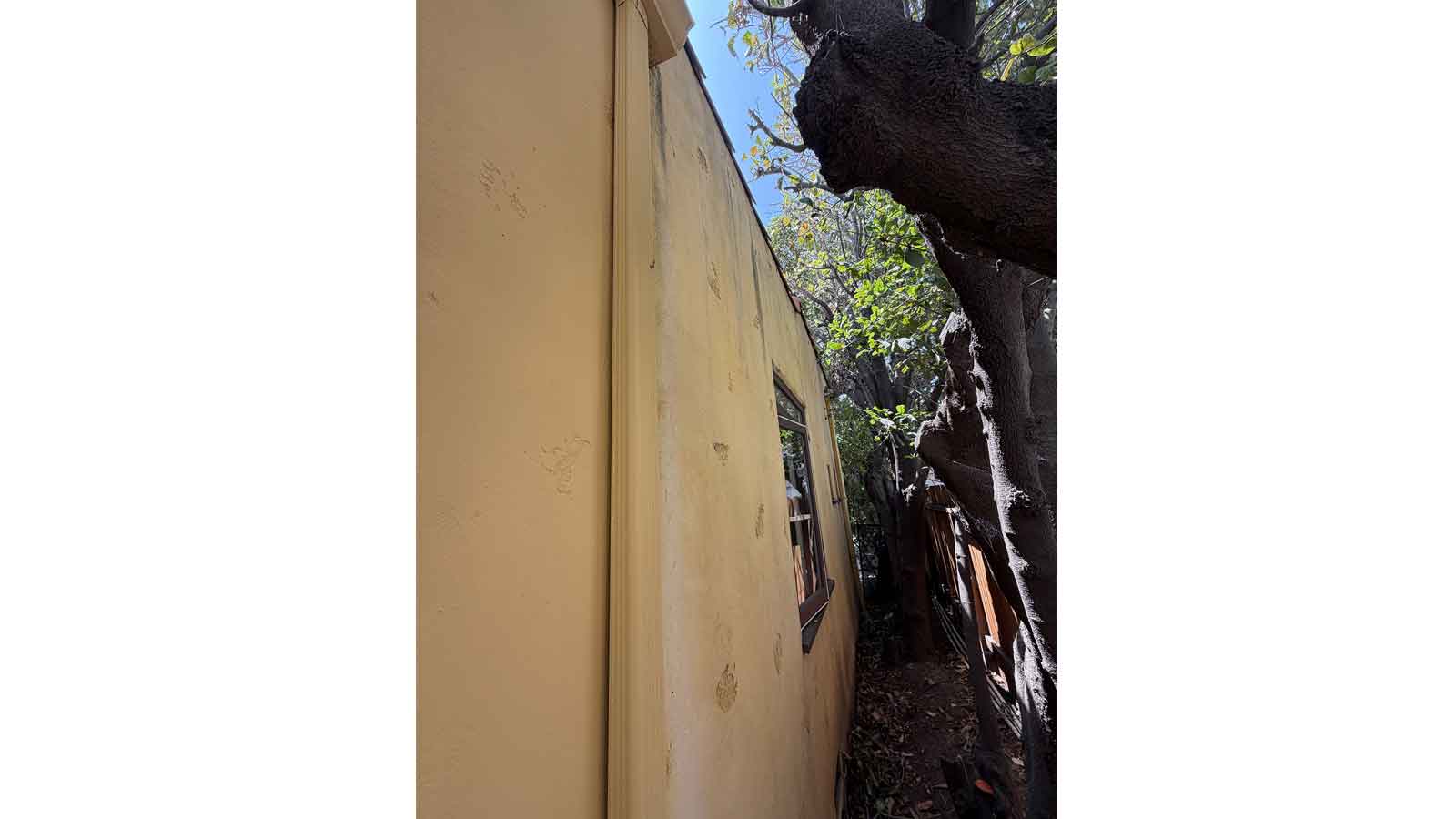 Damaged exterior stucco wall and window showing signs of water intrusion in Los Angeles